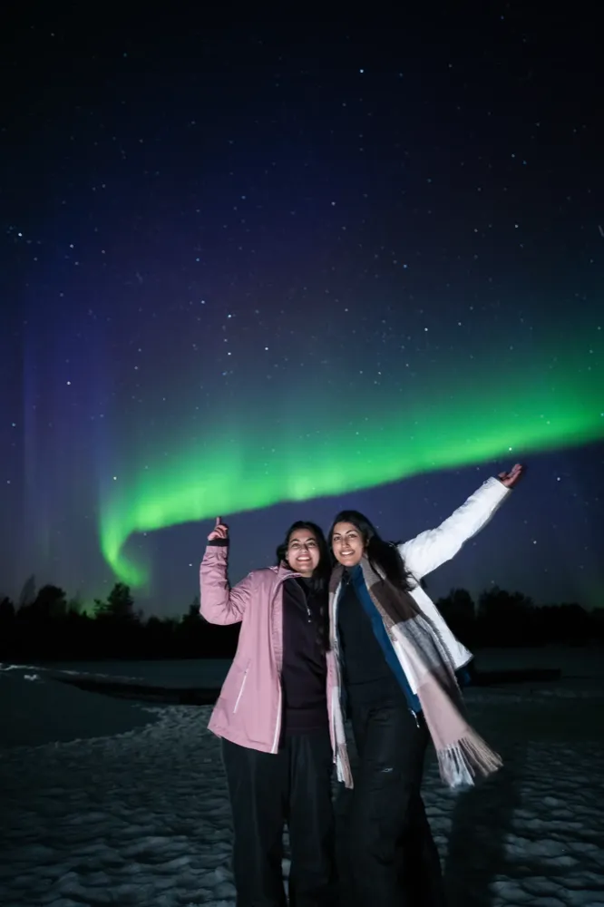 Ospiti che indicano l'aurora boreale durante una caccia con Experience Tours